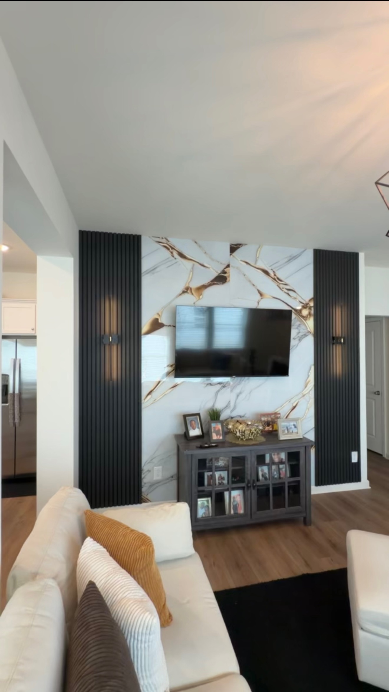 Living room accent wall with Black Acoustic Panels and gold-veined Marble Sheet